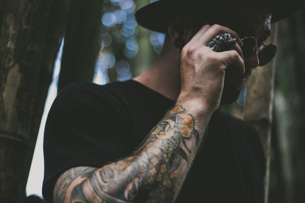 Projekt tatuaży rękawów wykonany na ręce mężczyzny rozmawiającego przez telefon