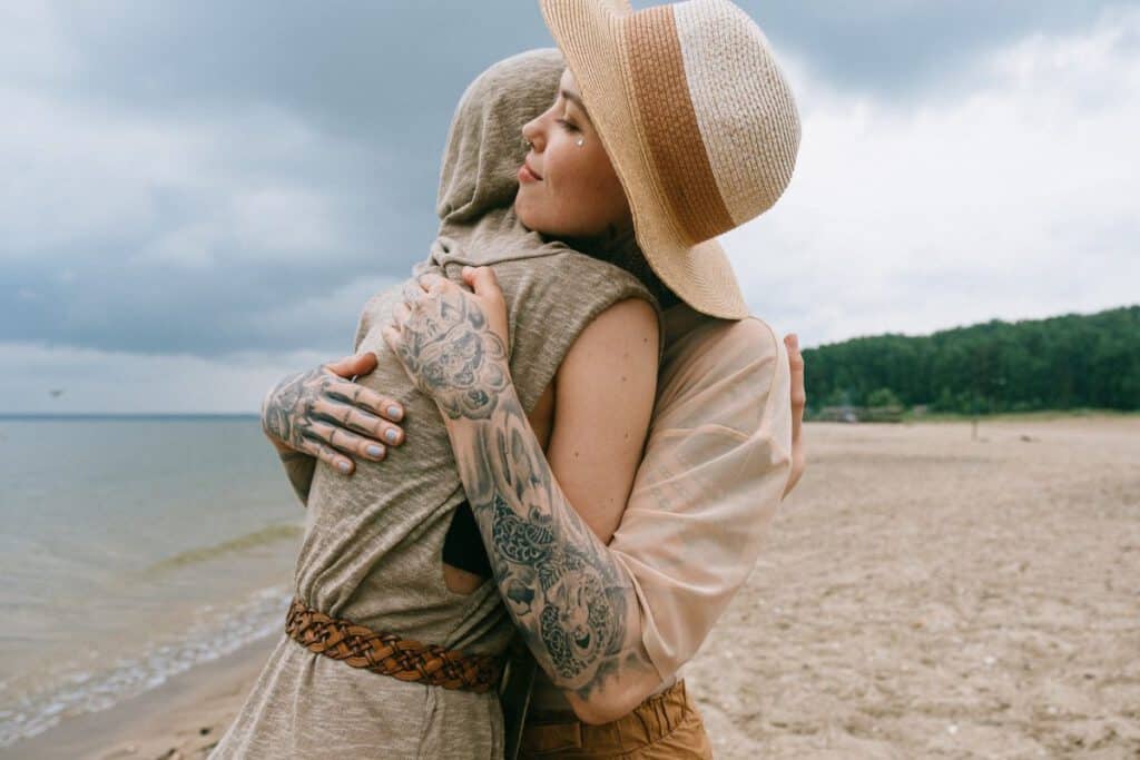 Kobieta z tatuażami na dłoni, która przytula swoja przyjaciółkę