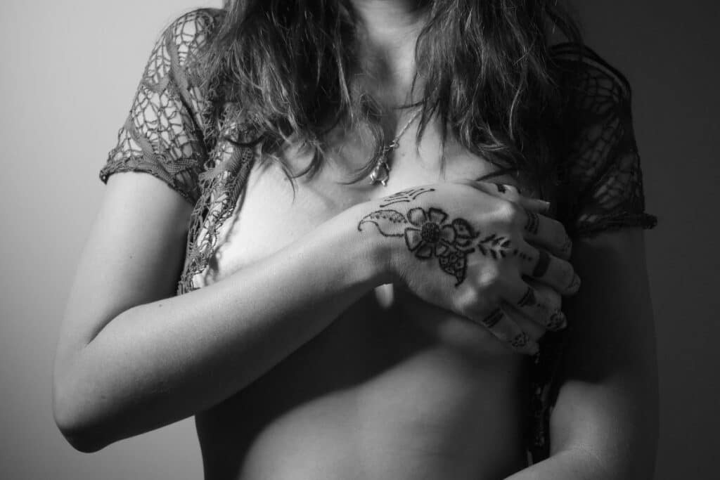 Kobieta trzymająca wytatuowana dłoń na piersi