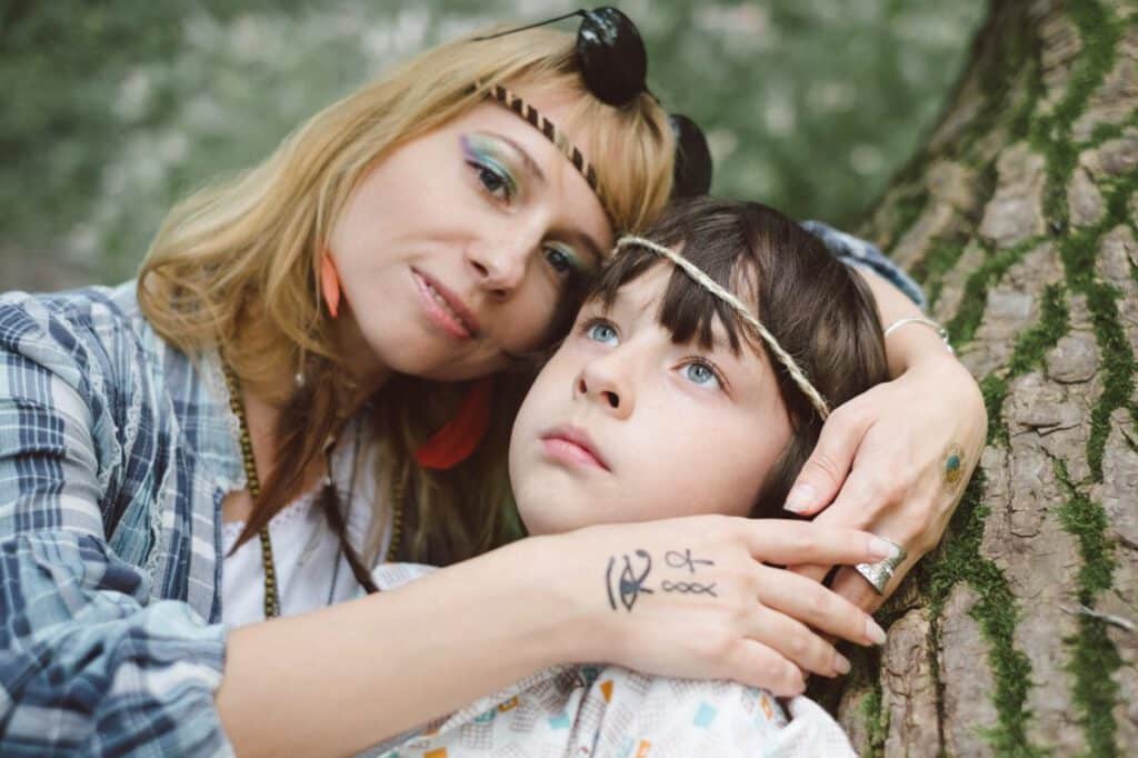 Mama z tatuażem na dłoni obejmująca swoje dziecko