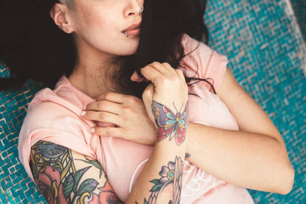 Kobieta mająca na dłoni tatuaż motyla