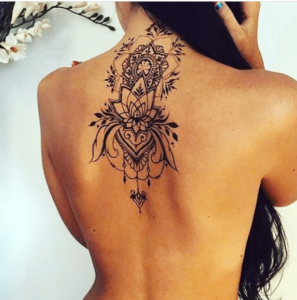 Młoda kobieta z damskim tatuażem na plecach