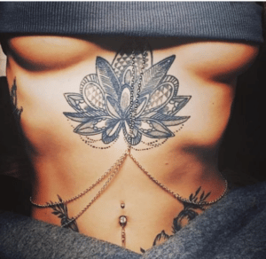 Kobieta z damskim tatuażem niędzy biustem
