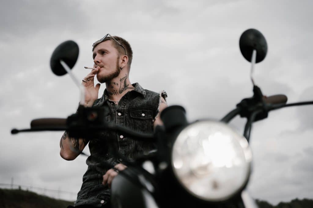 Wydziarany motocyklista palący papierosa