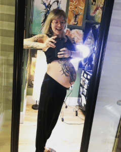 Kobieta z tatuażem na brzuchu w ciąży