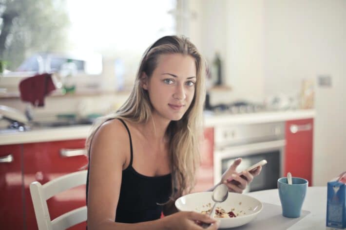 Kobieta jedząca śniadanie w formie płatków owsianych, stosująca dietę intermittent fasting
