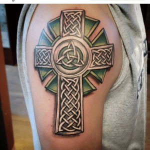 Krzyż celtycki został wykonany na przedramieniu mężczyzny w różnych barwach