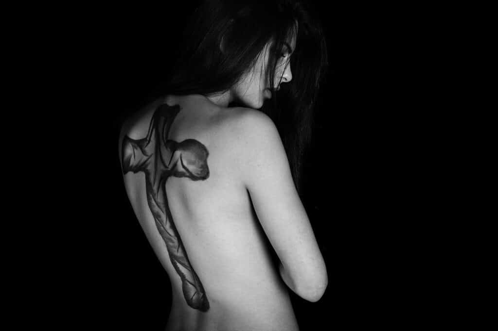 Tatuaż na całej długości pleców kobiety w kształcie krzyża 
