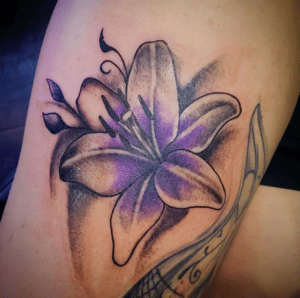 Fioletowy kwiat lilia jako tatuaż na ręce