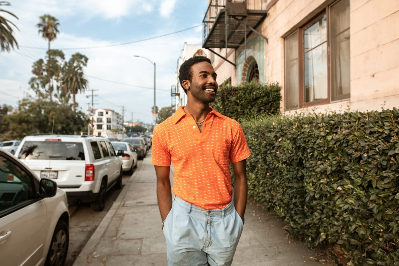 Biseksualny mężczyzna, uśmiechnięty biseksualista idzie po chodniku