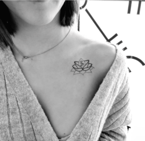 Kobieta z tatuażem kwiat lotosu na obojczyku