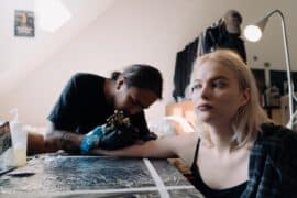 Kobieta robiąca tatuaż, u której może wystąpić uczulenie po tatuażu