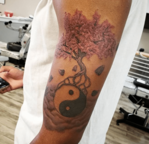 Drzewo wiśni z kwiatami jako tatuaż na ciele