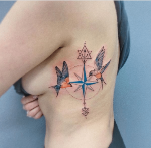 Kolorowy tatuaż kompas u kobiety na żebrach