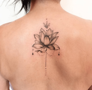 Tatuaż kwiat lotosu o wyjątkowym znaczeniu wydziarana na plecach kobiety