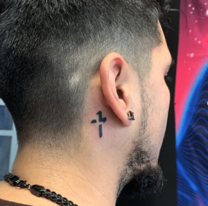 Młody mężczyzna z delikatnym tatuażem za uchem