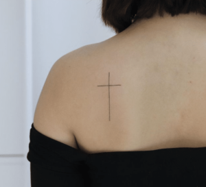 Kobieta z tatuażem krzyżem na ramieniu