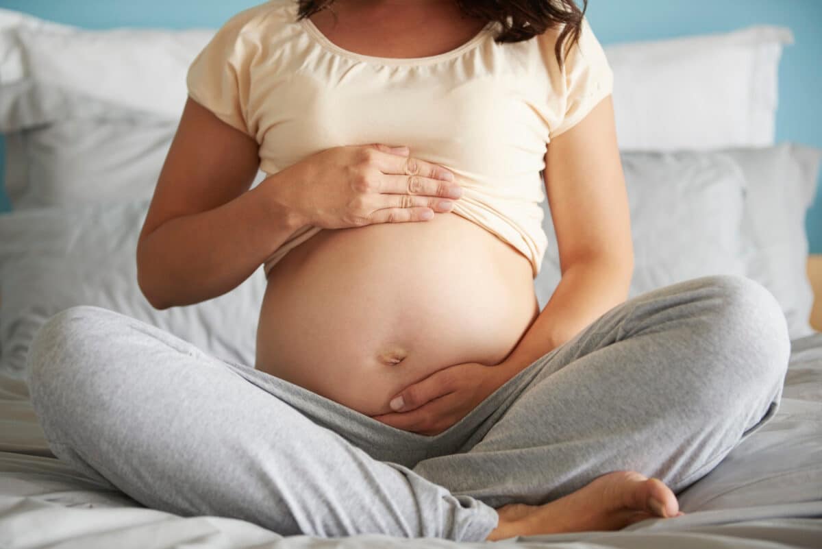 Kobieta w ciąży z bólem w okolicy pępka