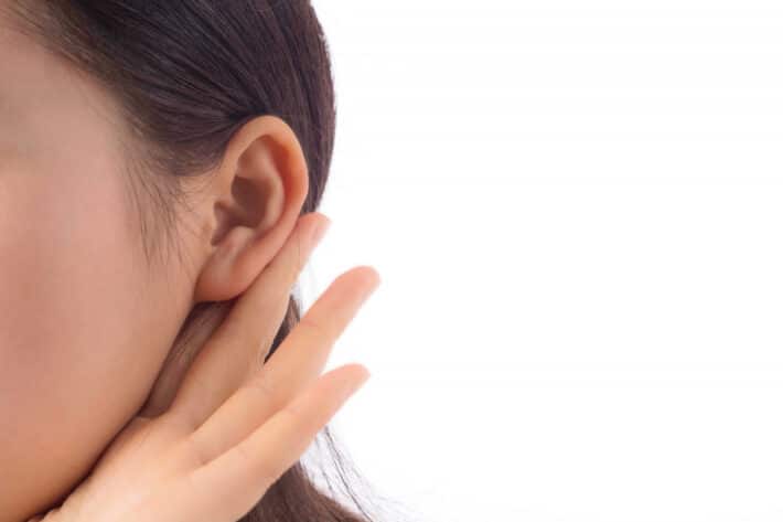Młoda kobieta wyczuwająca guzek za uchem i na szyi