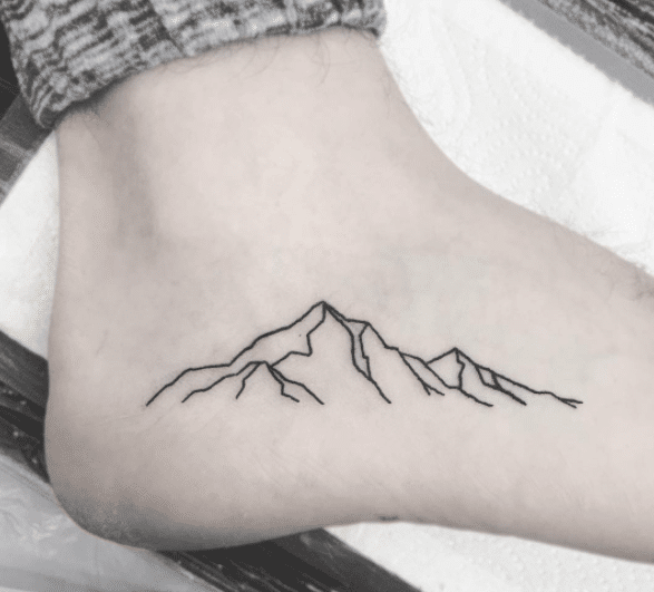 Tatuaż góry na stopie