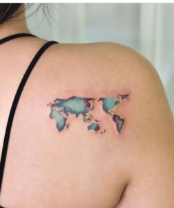 Tatuaż kontynenty świata na kobiecym ramieniu