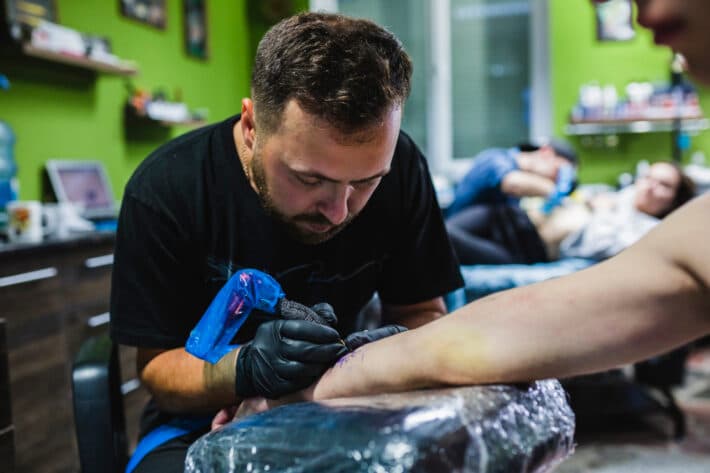 Mężczyzna wykonujący tatuaż linie