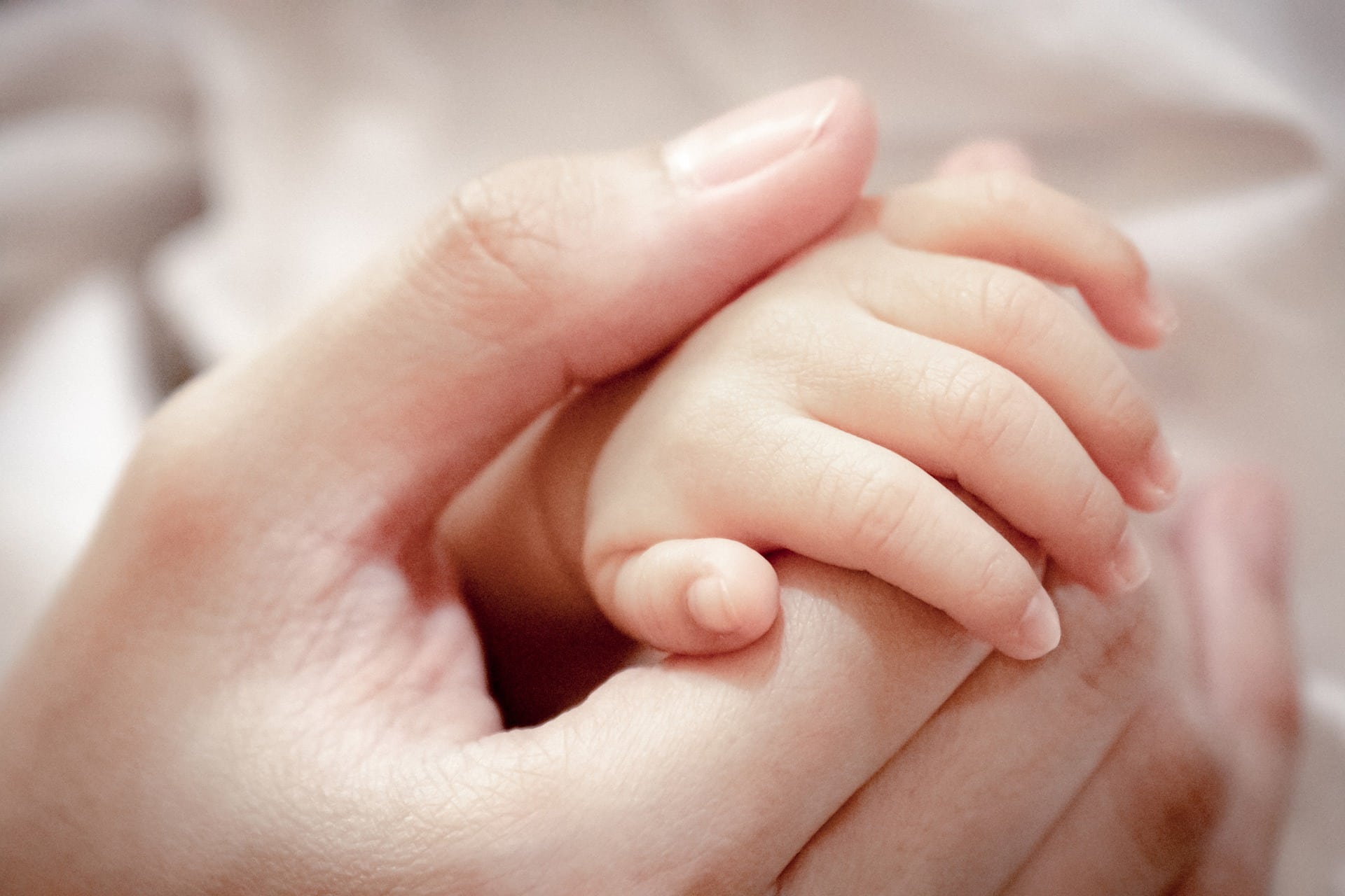 Kobieta trzyma delikatną rękę niemowlaka