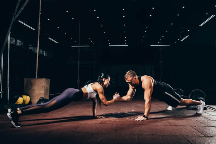 Kobieta i mężczyzna trenuja na siłowni