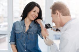 lekarz bada kobiecie zmiane na skórze