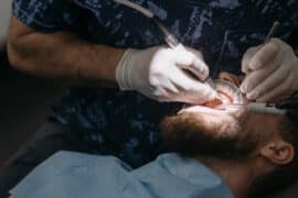 Mężczyzna u dentysty wstawia implanty zębów