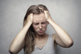 Kobiet z migrena trzyma się za głowe