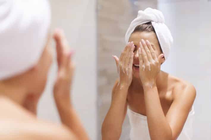 Kobieta myje twarz i używa kosmetyków do trądziku