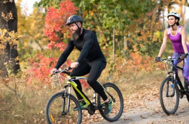 Osoby w jesiennych strojach rowerowych jadą na przejażdzkę rowerową