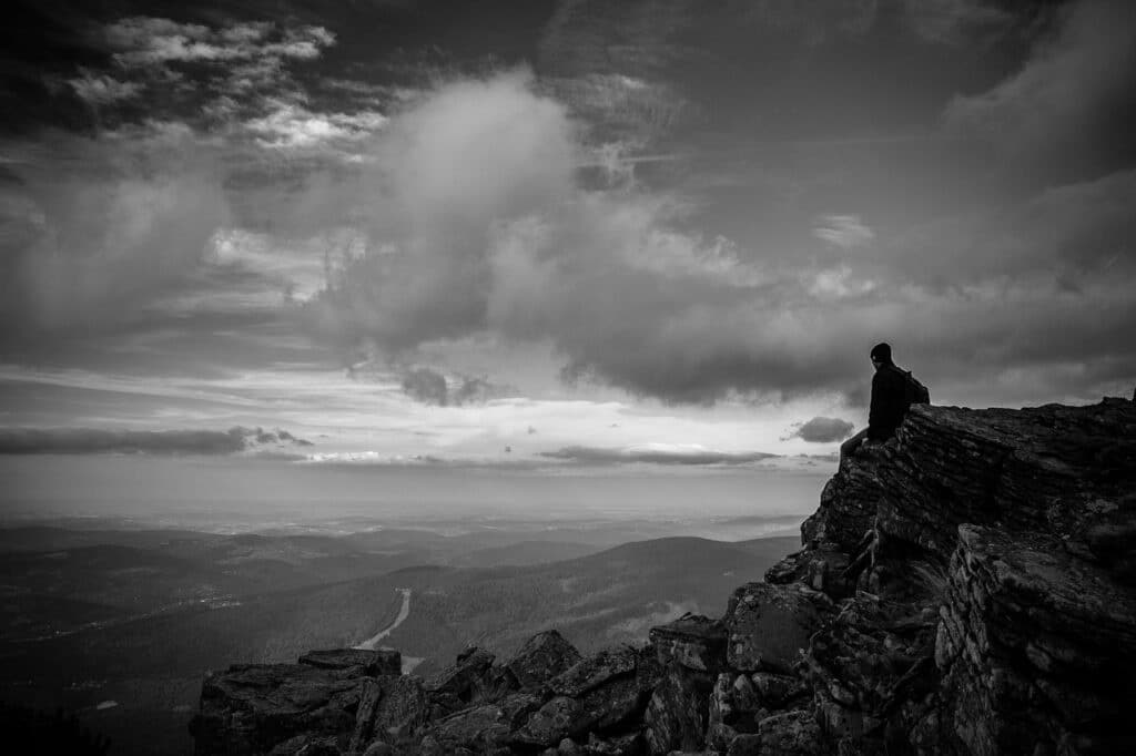 Człowiek siedzący na wierzchołku góry