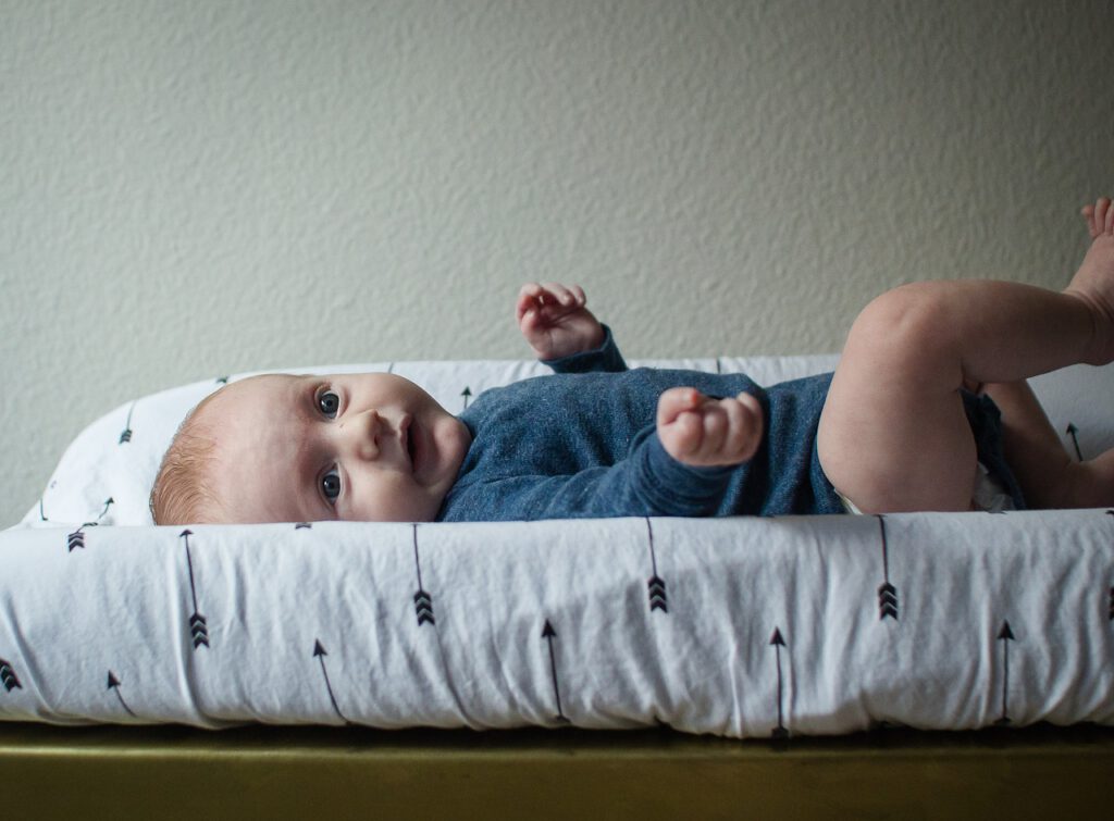 Noworodek leżący na przewijaku. Przewijak pomaga utrzymać plecy po porodzie w dobrej kondycji
