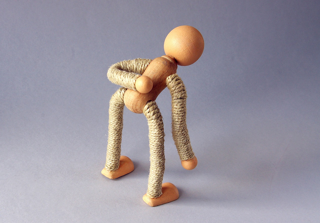 Drewniana figurka, symbolizująca ból pleców w odcinku lędźwiowwym
