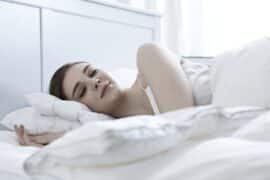 Kobieta śpiąca w łóżku, mająca marzenia senne
