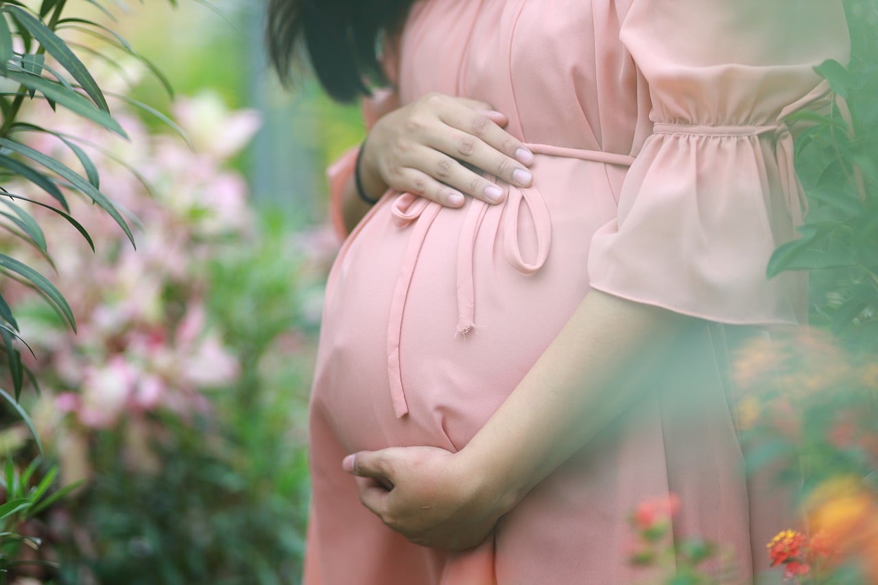 Kobieta w ciąży w różowej sukience