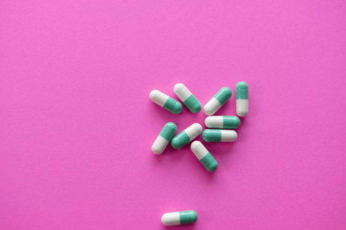 Leki przeciwbólowe leża ozsypane na różowym blacie