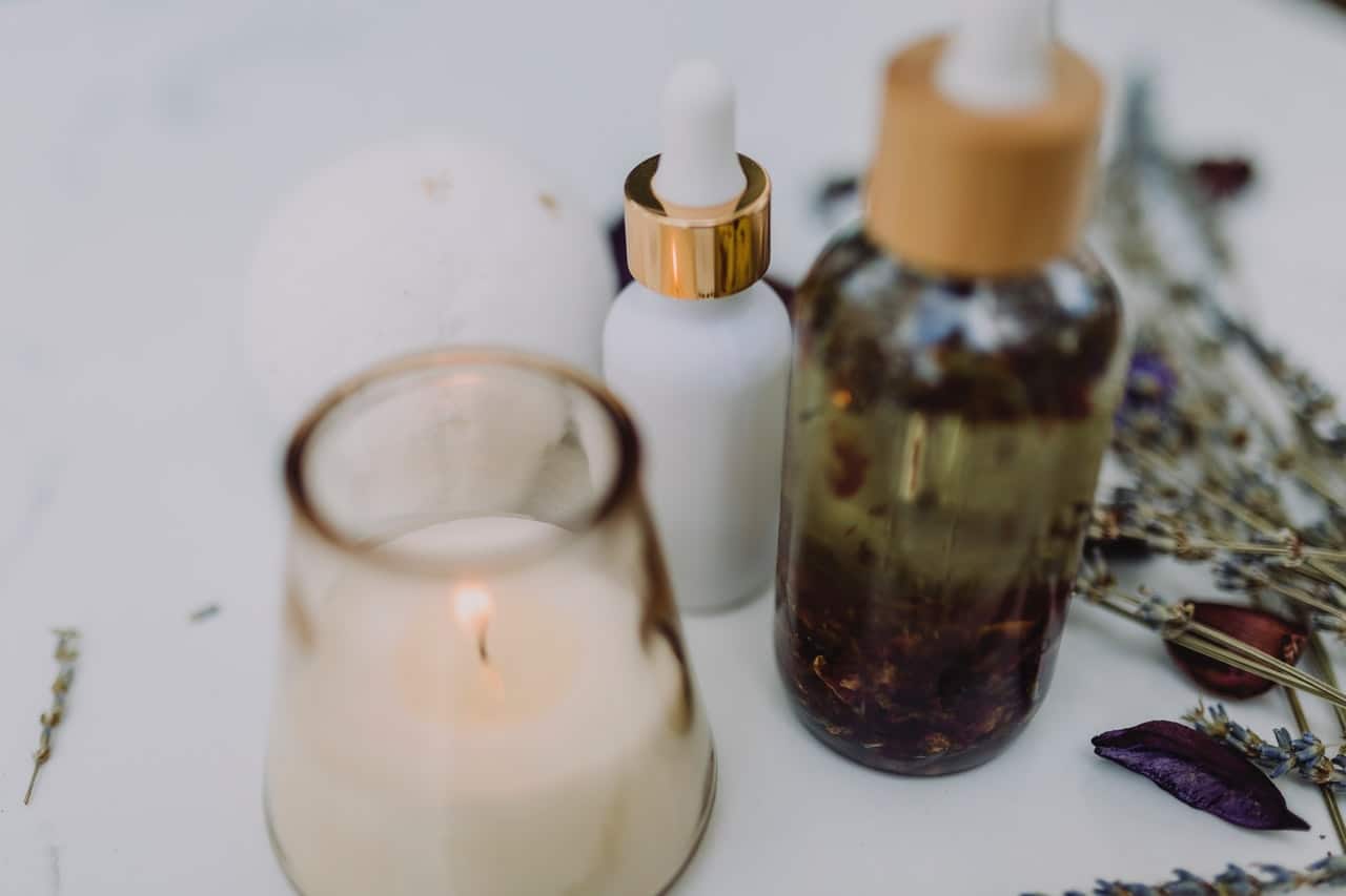 Oejki do aromaterapii stoją na stole obok świec