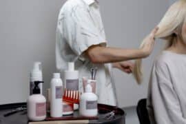 Mężczyzna w salne fryzjerskim korzysta z dobrych kosmetyków do włosów