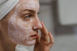 Kobieta po całym dniu oczyszcza swoją skóre twarzy w łazience