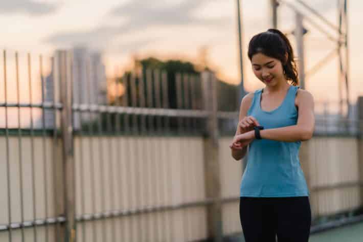 kobieta biegając ma na dłoni opaskę sportową