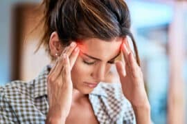 Kobieta zmaga się z bólem migrenowym