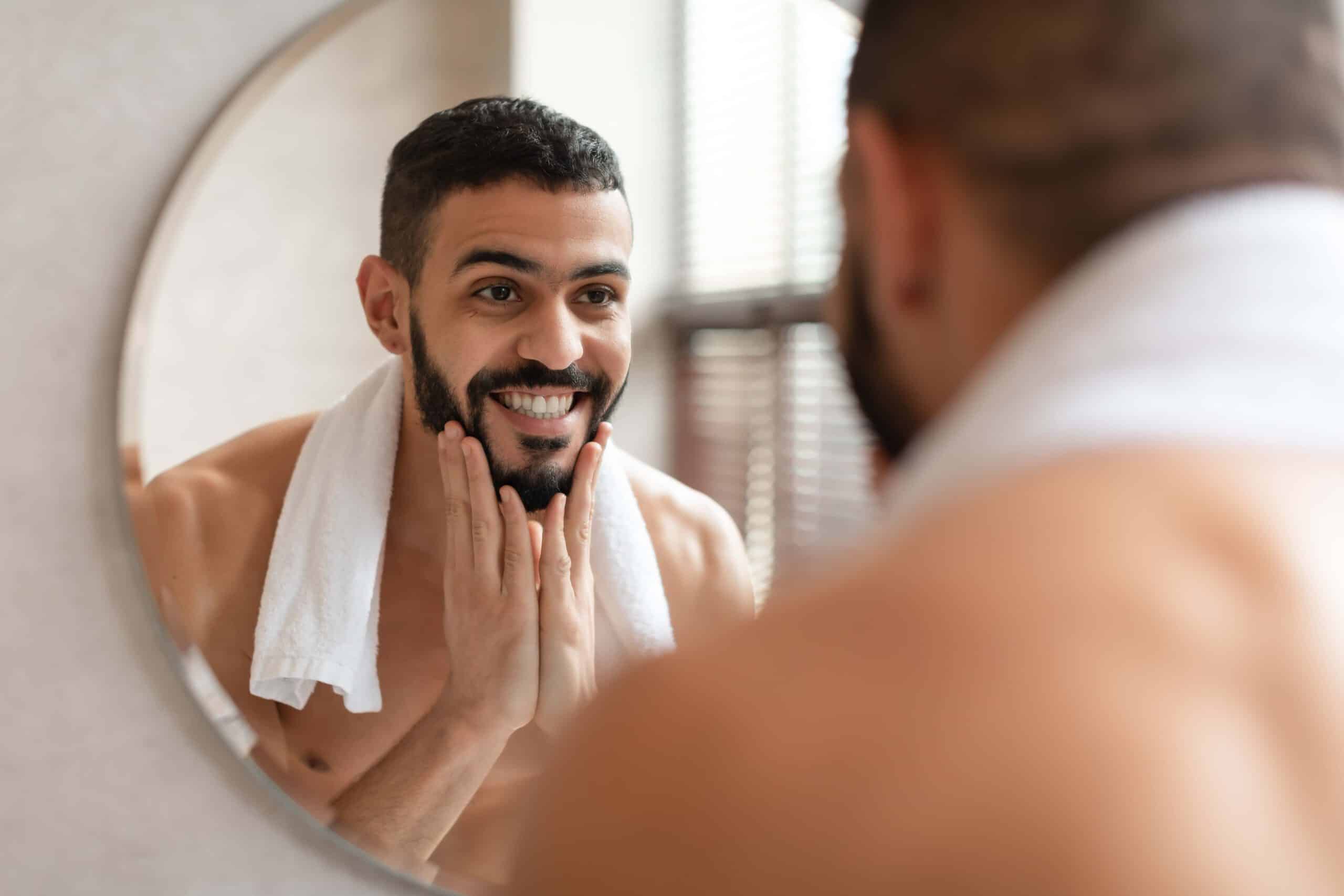Mężczyzna przed lustrem będzie golić brode