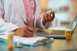 Kobieta w aptece wydaje leki z e-recepty