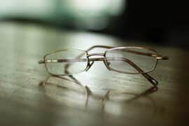Okulary leżą na drewnianym stole