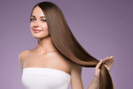 Kobieta z długimi i zadbanymi włosami korzysta z mgiełki do włosów