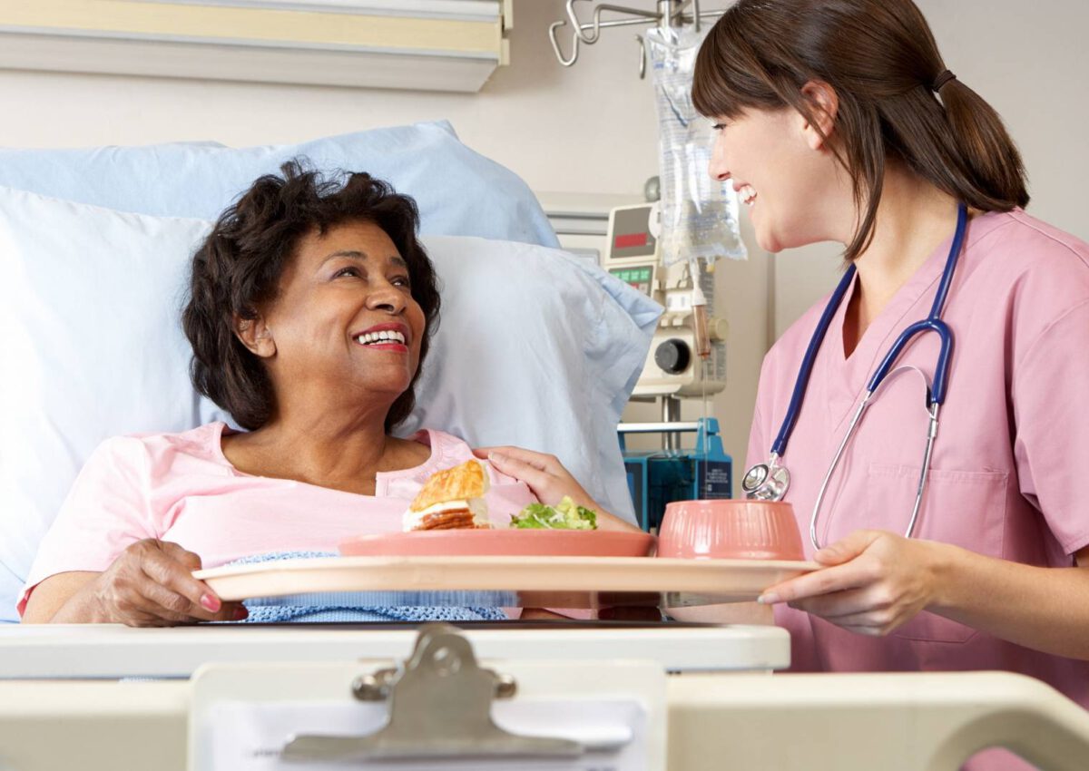 Kobieta która jest w szpitalu dostaje jedzenie od pielęgniarki