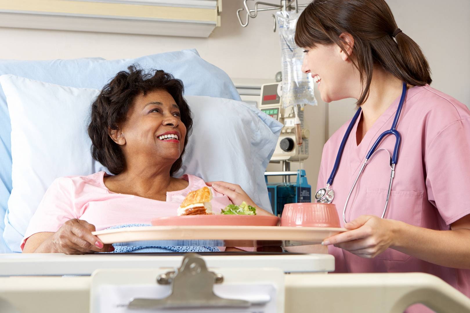 Kobieta która jest w szpitalu dostaje jedzenie od pielęgniarki